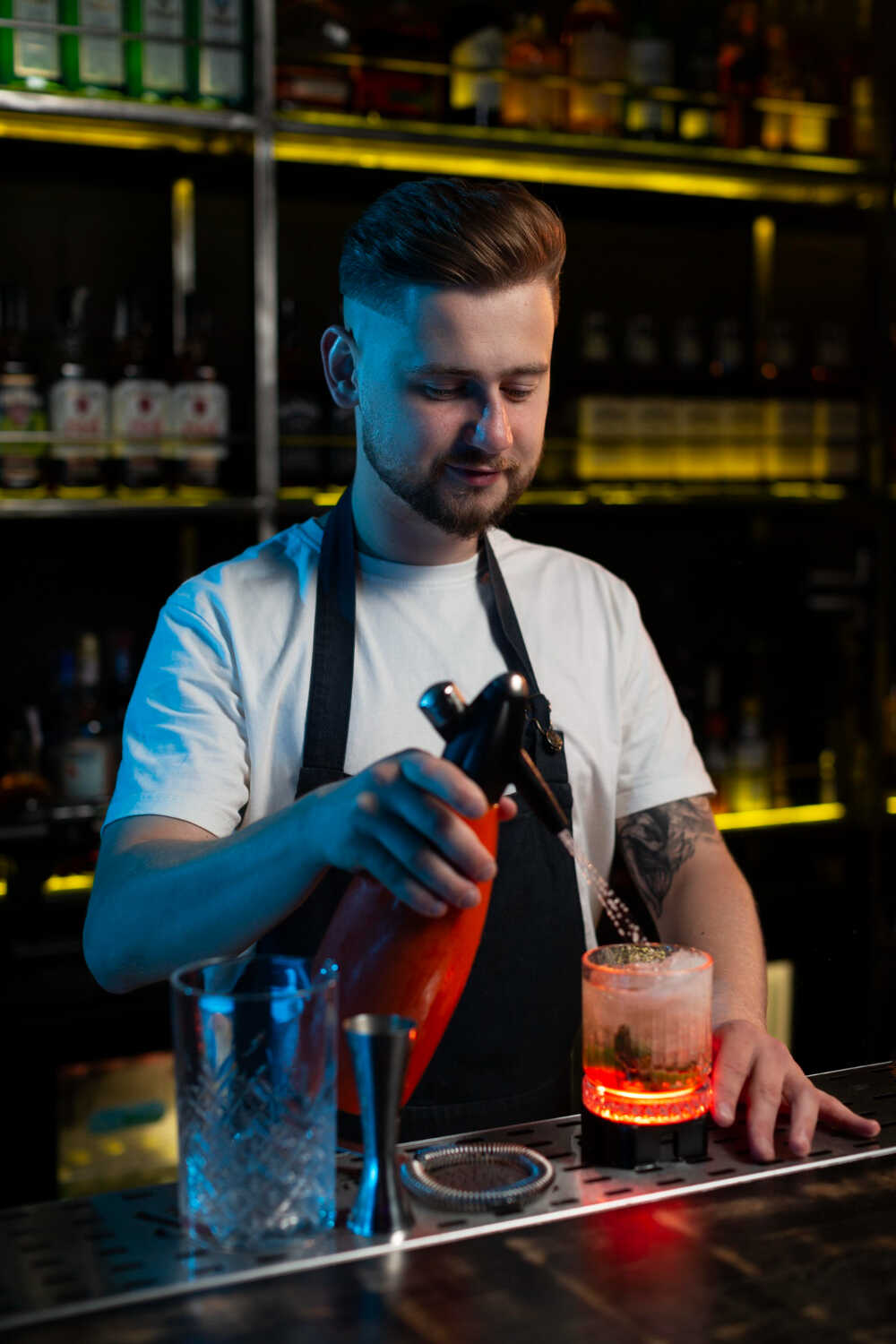 Bartender maakt een cocktail in een bar met neonverlichting